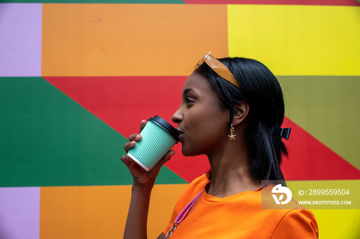 Young woman drinking take-out coffee outdoors