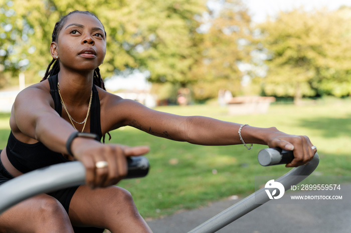 Young woman exercising in outdoor gym