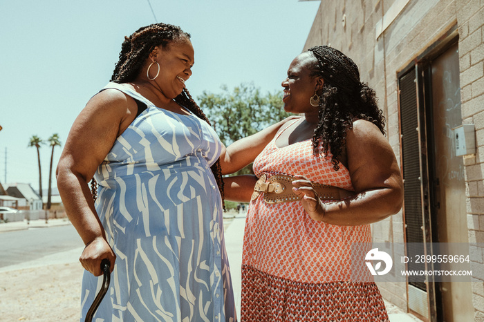 2 plus size African American women embrace and talk