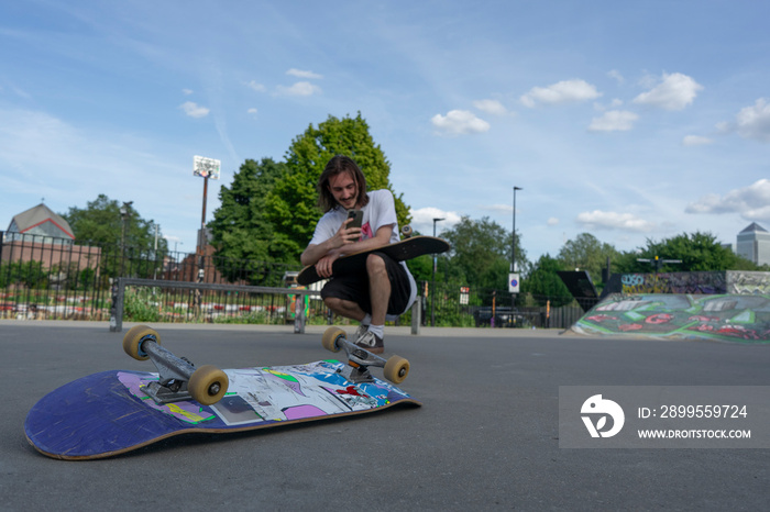 Skateboarder recording video in skate park