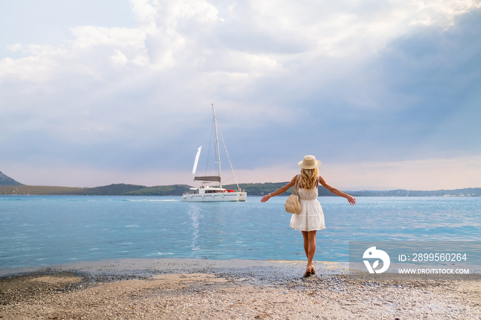 Beautiful girl tourist walking at Ermioni marina seaport, Greece