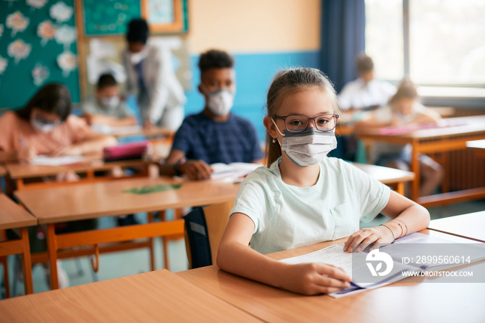 Schoolgirl wearing face mask while having class at school during COVID-19 pandemic.