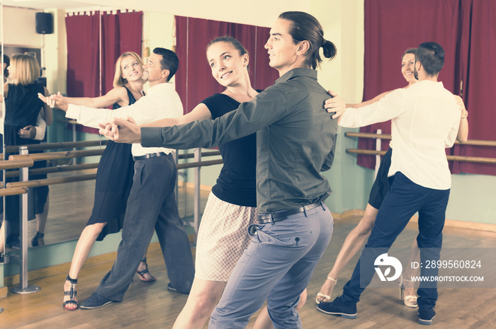 men and women enjoying of tango in class