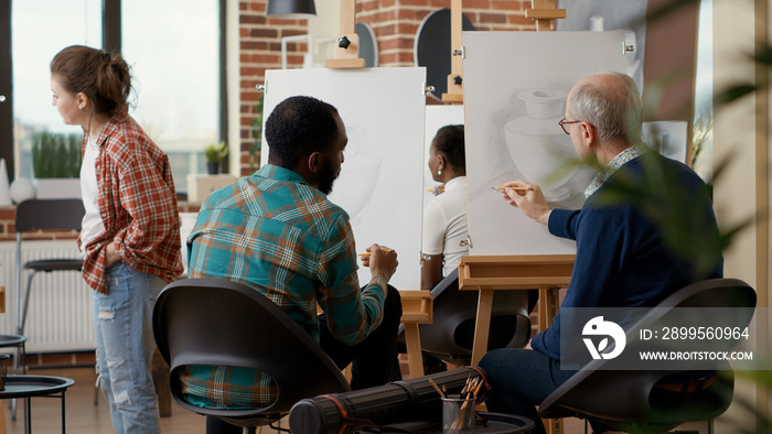 Team of young man and elder person attending art school class together to learn drawing skills for personal development and growth. Educational program to draw artwork sketch.