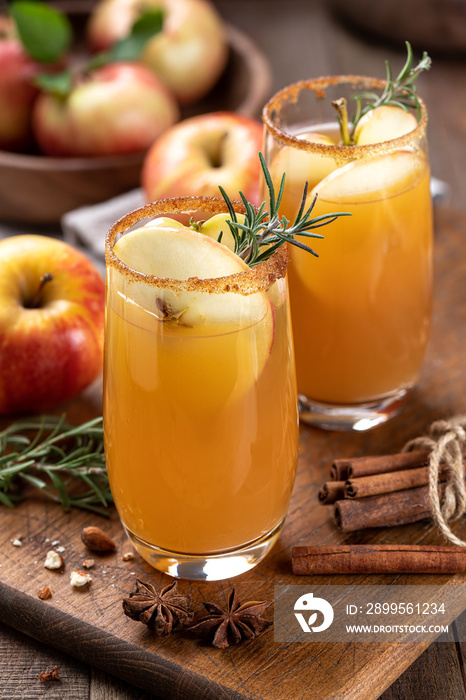 Apple cider cocktail with sliced apples and rosemary