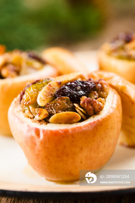 Fresh baked stuffed apple with walnut, almond, raisin, sultana, butter, sugar and cinnamon, a traditional autumn and winter dessert (Selective Focus, Focus in the middle of the image)