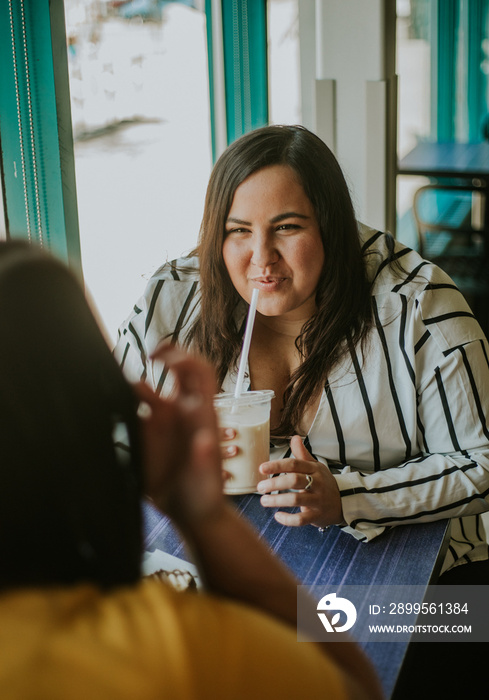 plus size Metis woman sips iced coffee