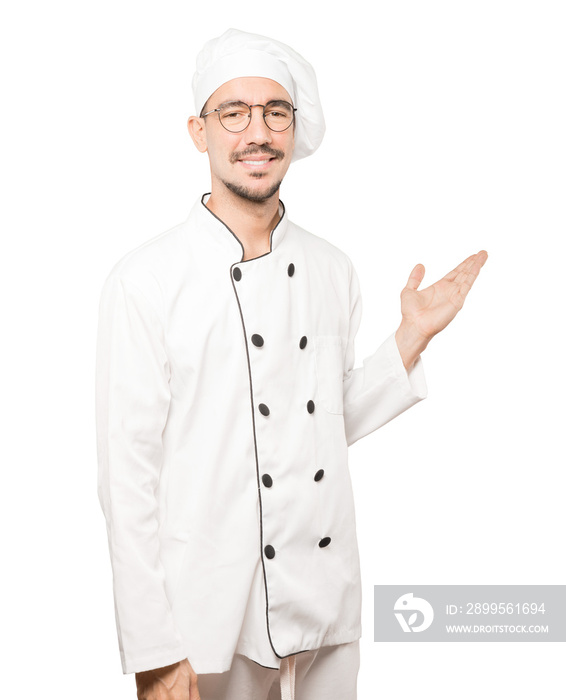 Friendly young chef making a gesture of welcome