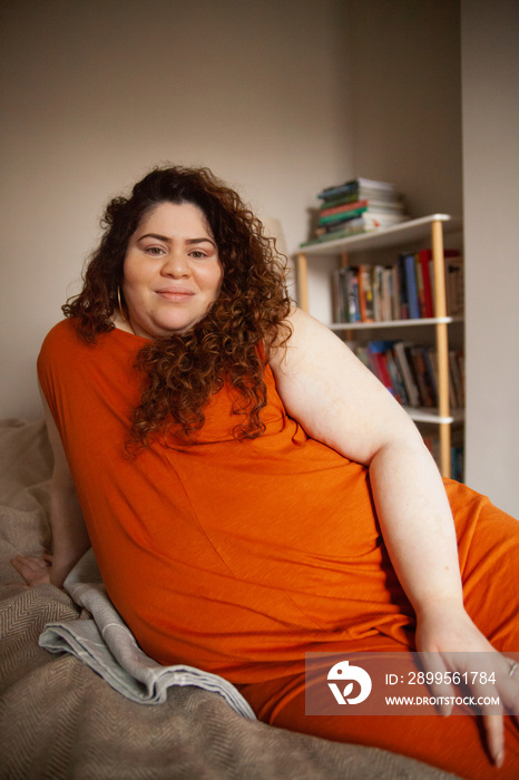 Plus-sized Sri Lankan woman with vitiligos sitting on her bed