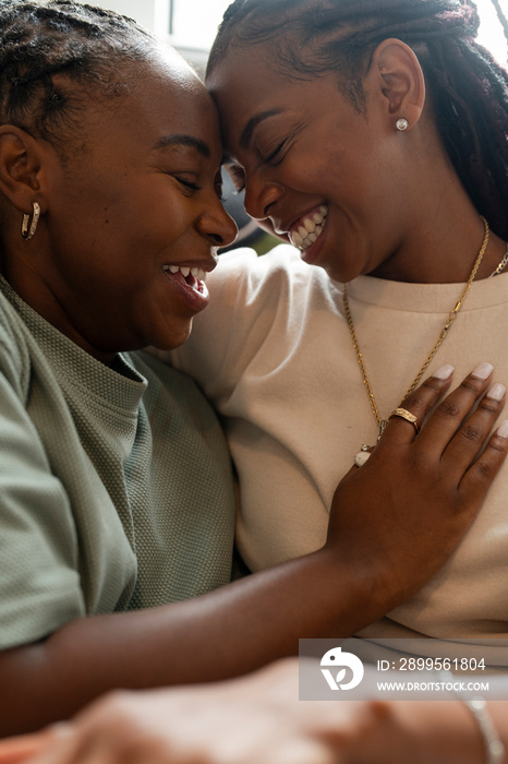 Portrait of smiling lesbian couple embracing at home