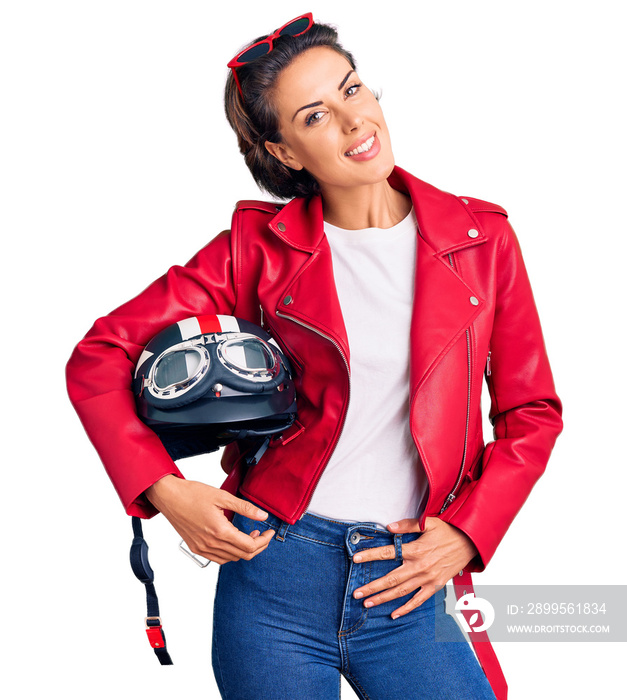 Young beautiful woman holding motorcycle helmet looking positive and happy standing and smiling with a confident smile showing teeth