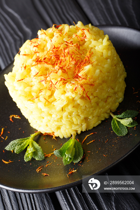 Italian risotto alla milanese with saffron closeup on a plate. vertical