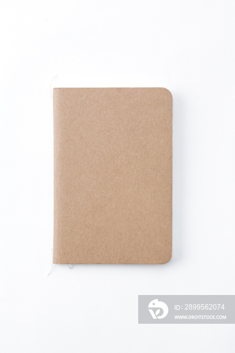 Top view of closed stitch blank recycled paper cover notebook on white background.