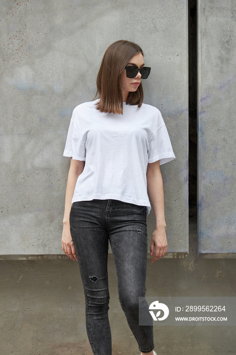 Girl or woman wearing white blank t-shirt with space for your logo, mock up or design in casual urban style