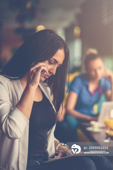 Young woman using mobile phone in front of her team in startup office