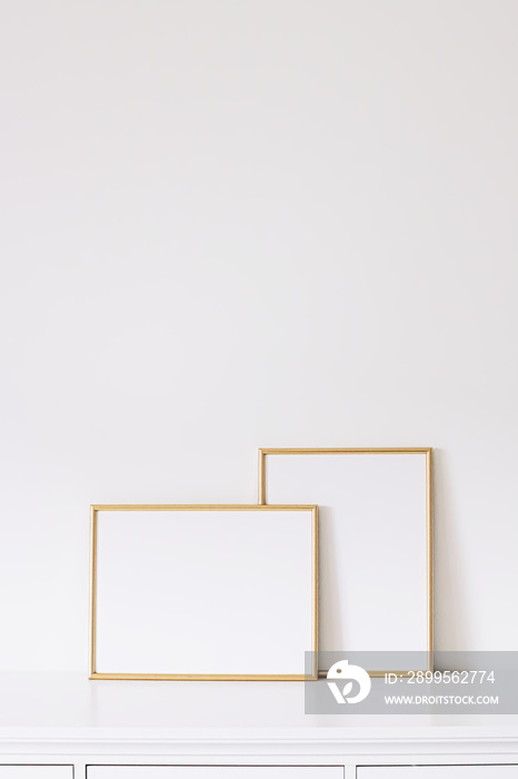 Two golden vertical and horizontal frames on white furniture, luxury home decor and design for mockup creation