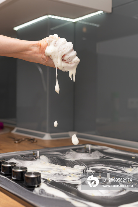 Woman’s hand cleaning gas stove