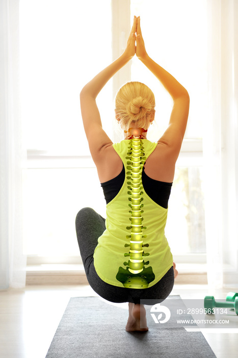 Young woman practicing yoga in gym. Concept of healthy spine