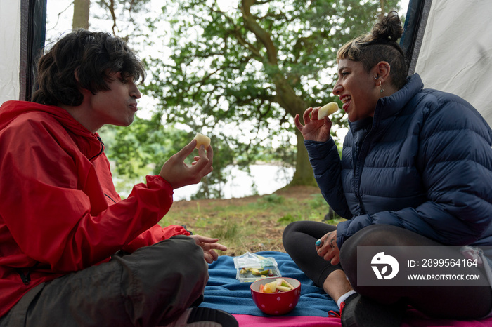 Mother and son eating snacks in tent