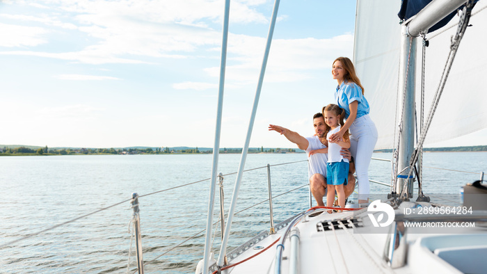 Happy Family Embracing Standing On Yacht Looking Pointing Aside Outdoors