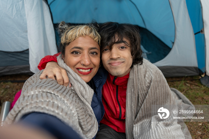 Portrait of mother and son sitting in tent