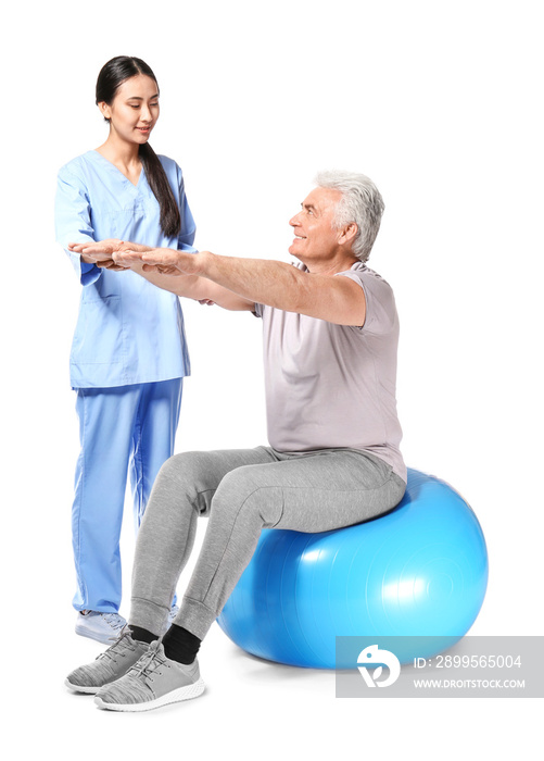 Young Asian physiotherapist working with mature man on white background