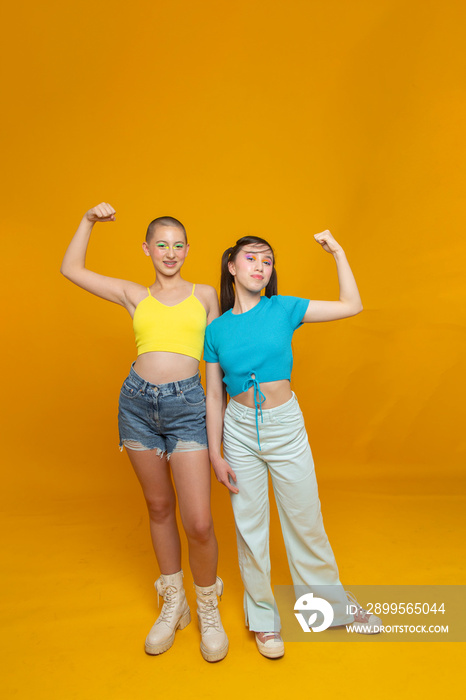 Studio portrait of stylish friends flexing muscles