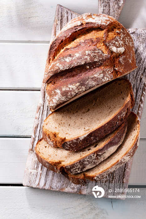 Sliced rye bread on cutting board, closeup..