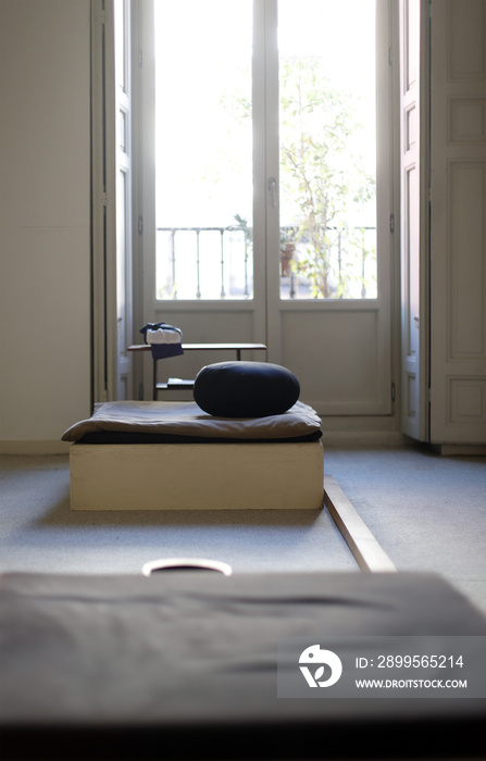 cojín para meditar en zazen en sala zen de meditación con balcón de fondo