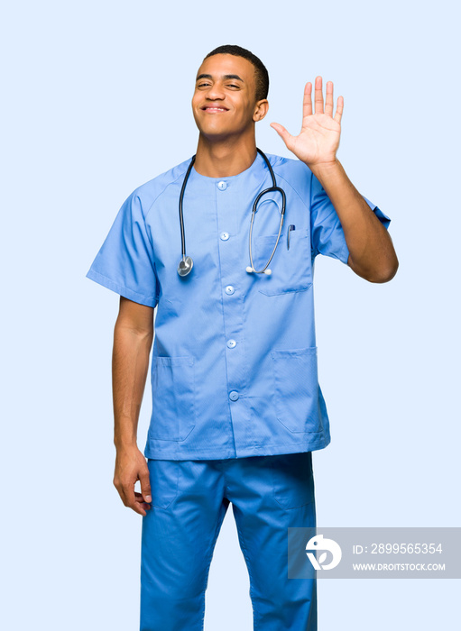 Surgeon doctor man saluting with hand with happy expression on isolated background