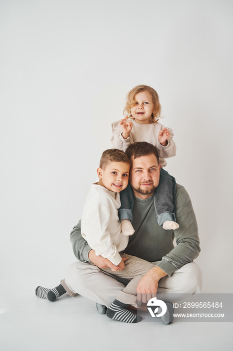 Happy family. Father, daughter and son hugging and smiling on white background. Paternity. Single father bring up his children.