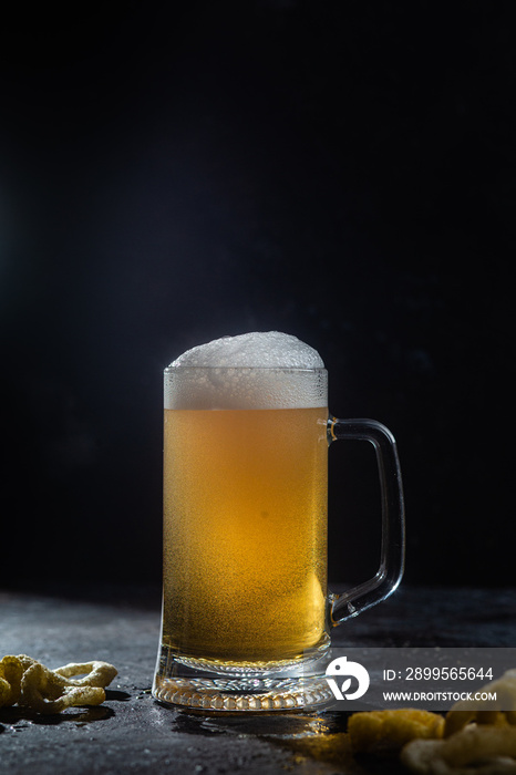 Light beer in a glass on a dark background