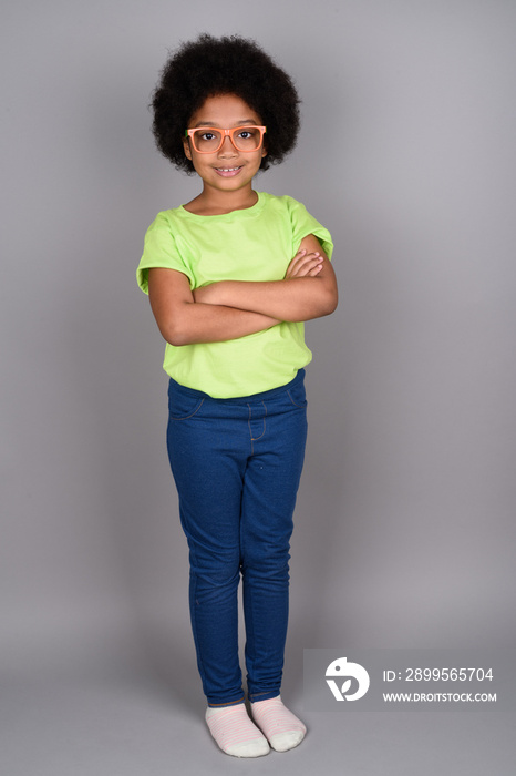 Young cute African girl against gray background