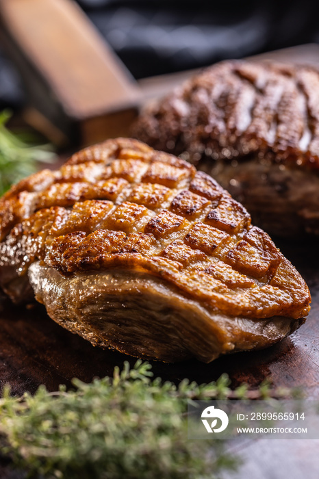 Duck breast perfectly baked until golden brown on cutting board.