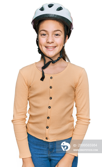 Beautiful brunette little girl wearing bike helmet looking positive and happy standing and smiling with a confident smile showing teeth