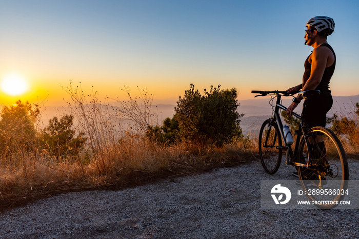 Male biker watching the sunset