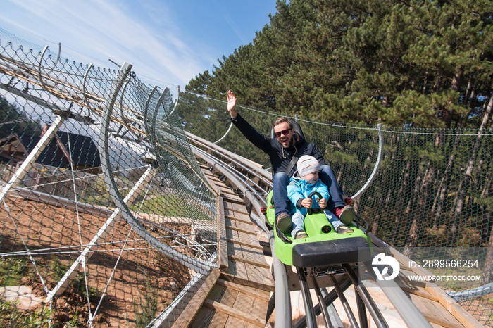 father and son enjoys driving on alpine coaster