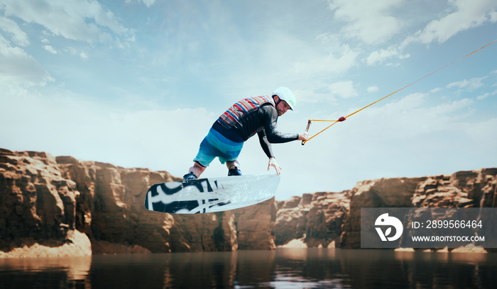 Wakeboarder making tricks on the river. Wakeboarding. Water sports.