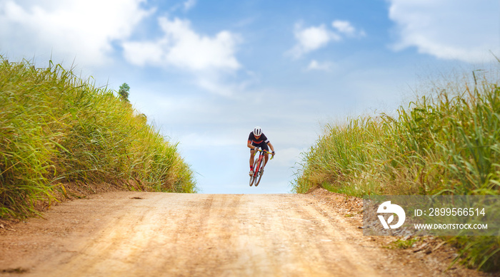 Asian man cycling on gravel road. He jumps action.