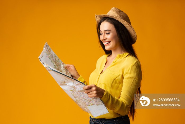 Smiling Lady Holding Tourist Map On Yellow Studio Background