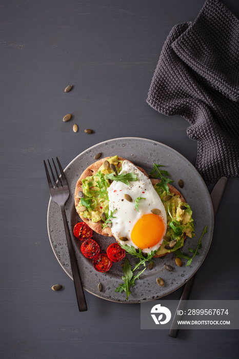 breakfast avocado sandwich with fried egg and tomato