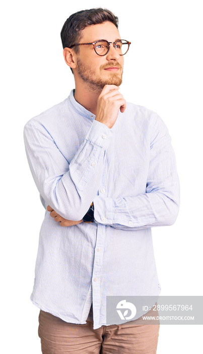 Handsome young man with bear wearing elegant business shirt and glasses with hand on chin thinking about question, pensive expression. smiling and thoughtful face. doubt concept.