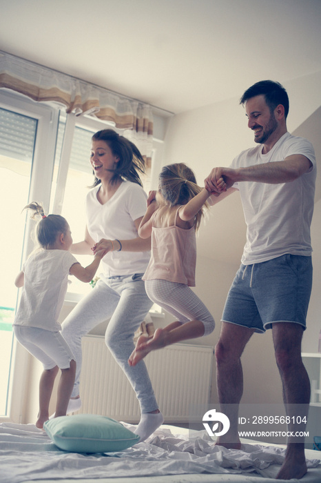 Happy family having fun on bed.