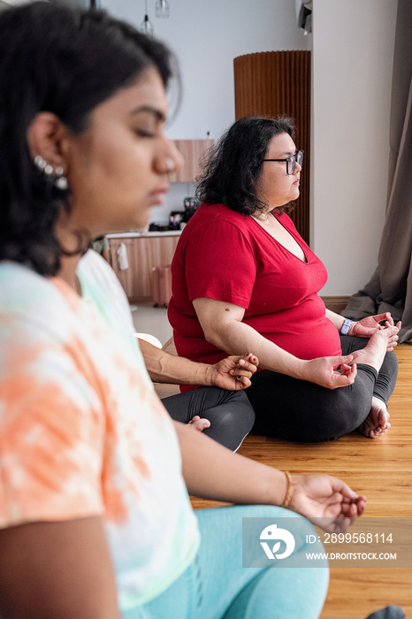 Group of friends meditating and doing yoga at home