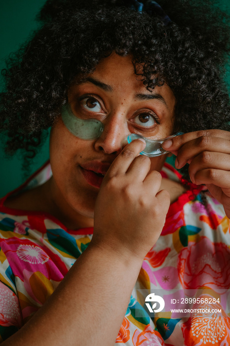 closeup of a plus size black person applying cooling eye pads