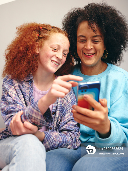 Mother and daughter looking at smart phone