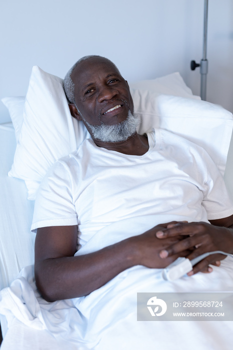 Portrait of african american male patient lying on hospital bed smiling to camera