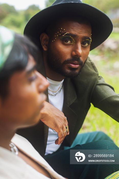 Two Malaysian Indian men surrounded by nature, walking in the grass, laughing together