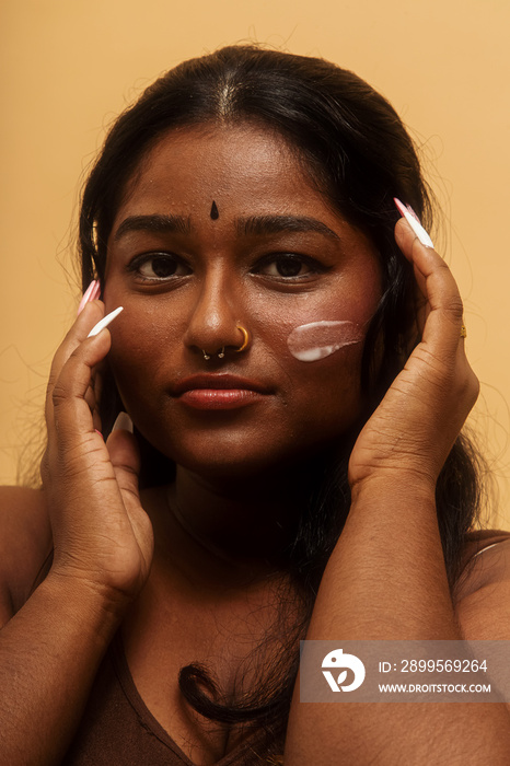 South Asian female solo lifestyle studio portrait skin care shot