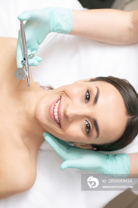 Confident woman smiling at the oxygen spray treatment